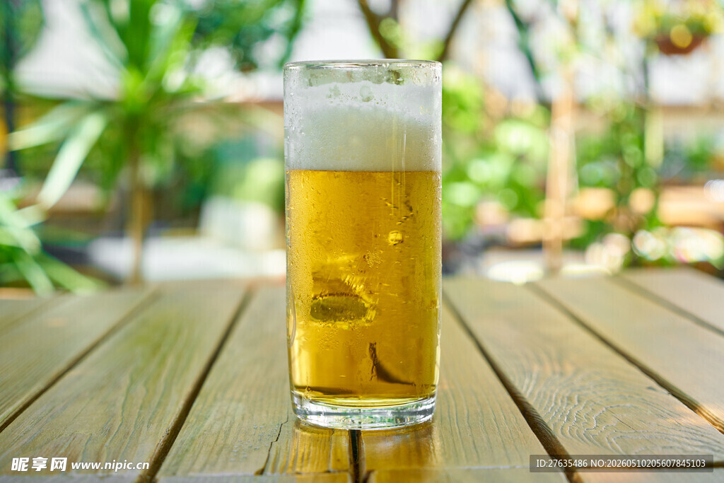 木桌上的一杯泡沫啤酒