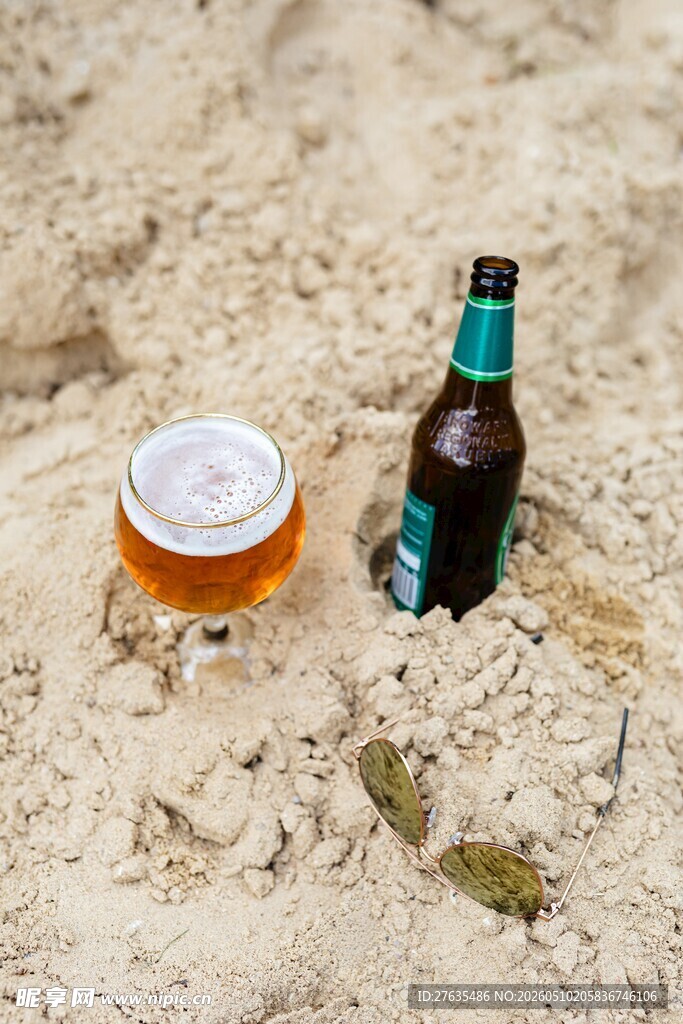 沙滩上的啤酒与玻璃杯