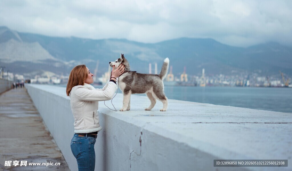 女子与狗在海边亲昵互动