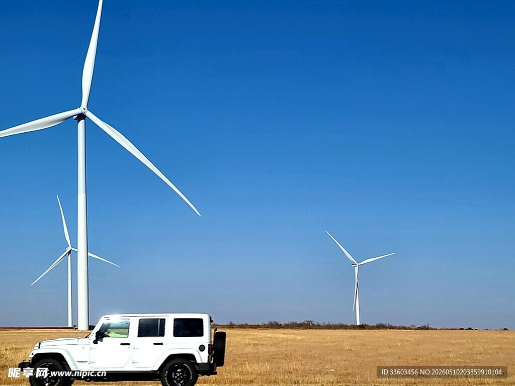 旷野风车旁的白色越野车