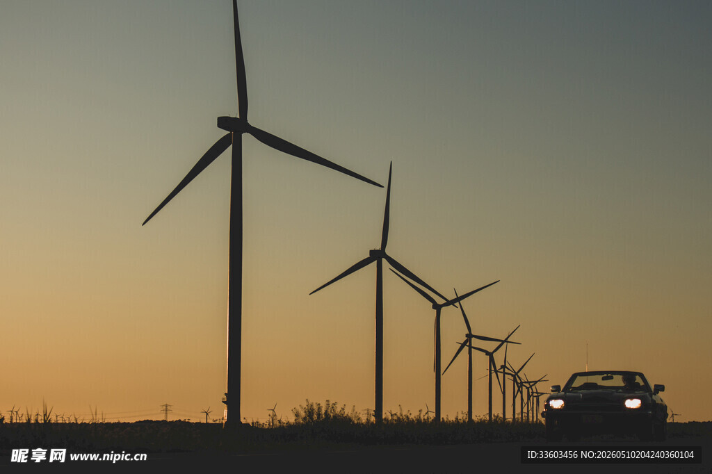 夕阳下公路旁的风力发电机组