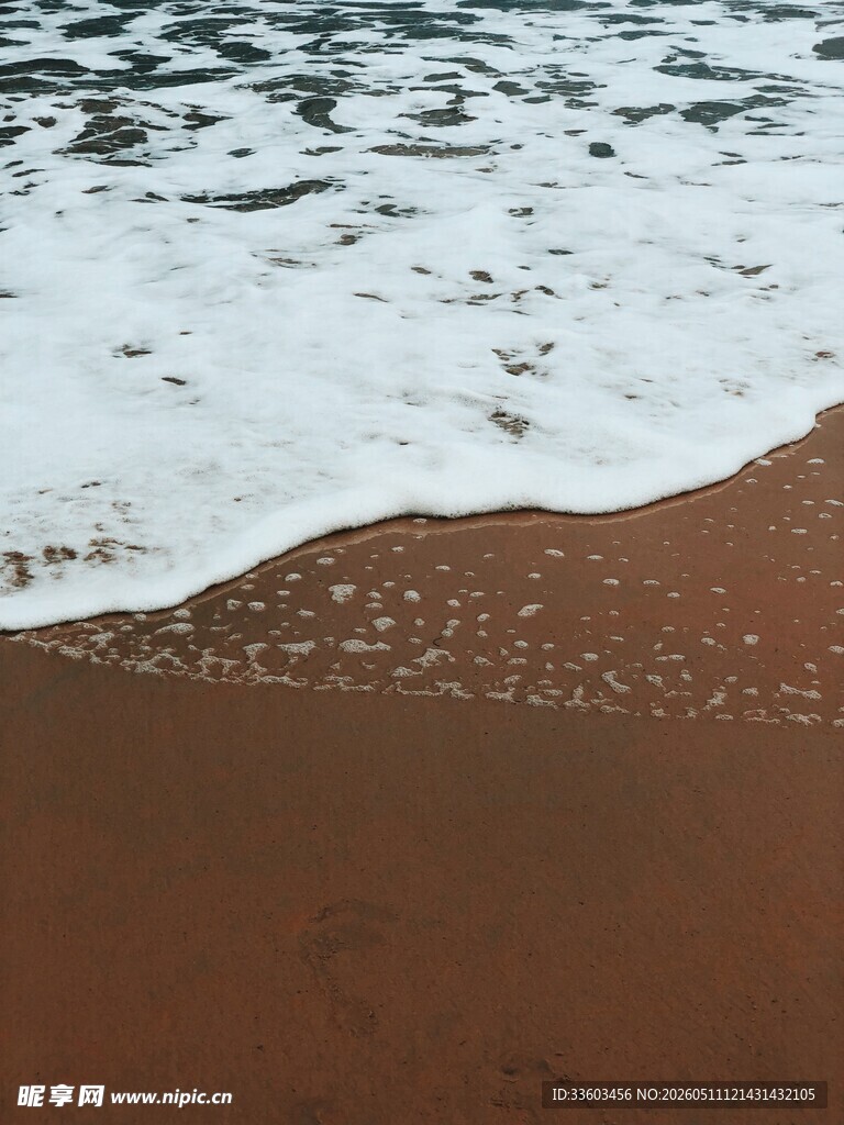 海浪轻吻红棕色沙滩