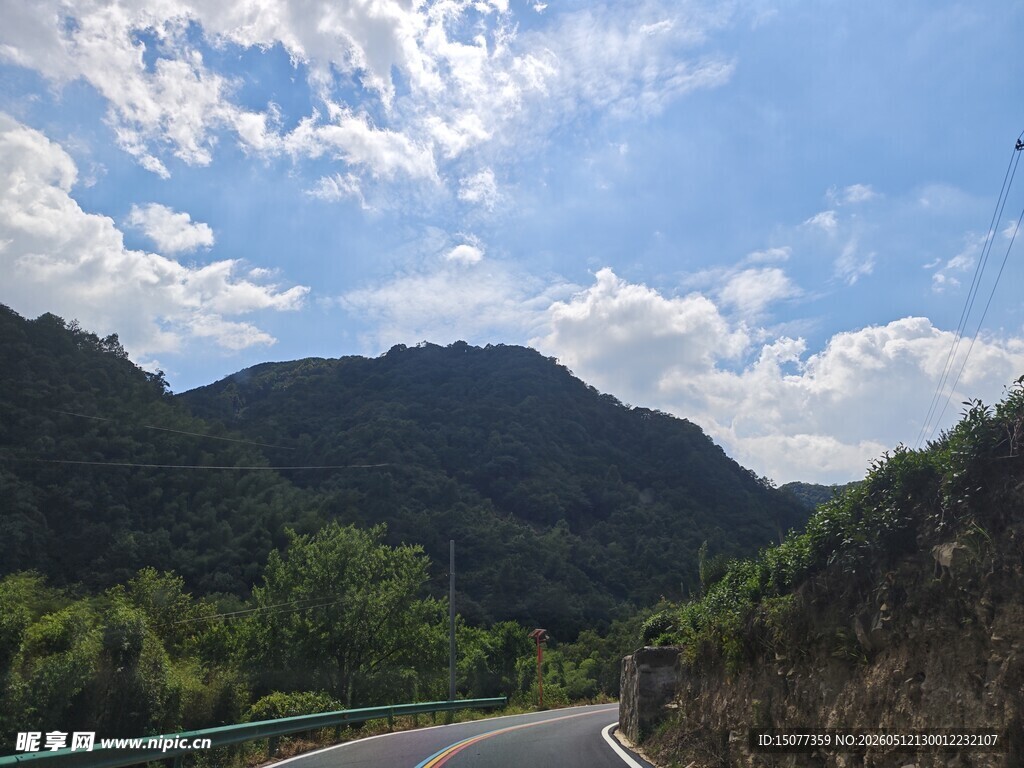 山间蜿蜒公路蓝天白云相伴