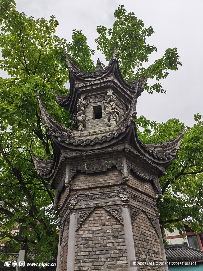 古朴六角石塔隐于绿树间