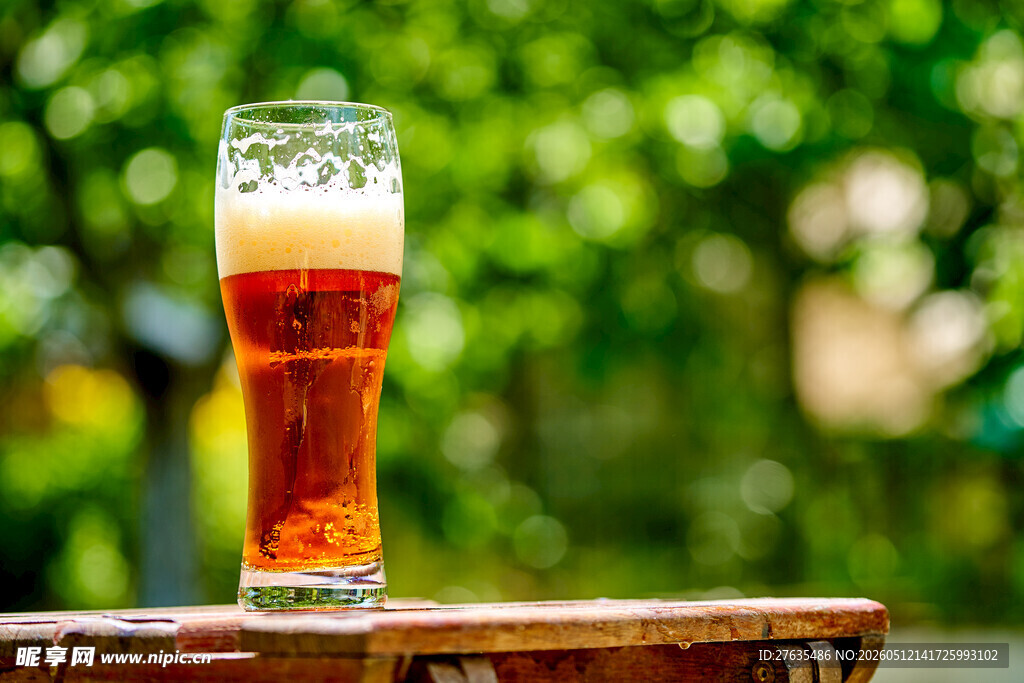 户外木桌上的一杯鲜啤酒