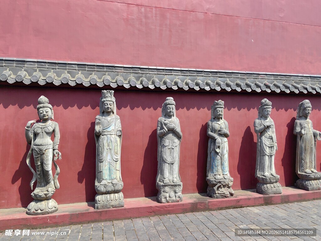 红墙下的一排古代人物雕像