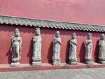红墙下的古代人物雕像