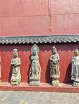 红墙下的精美古代人物雕像