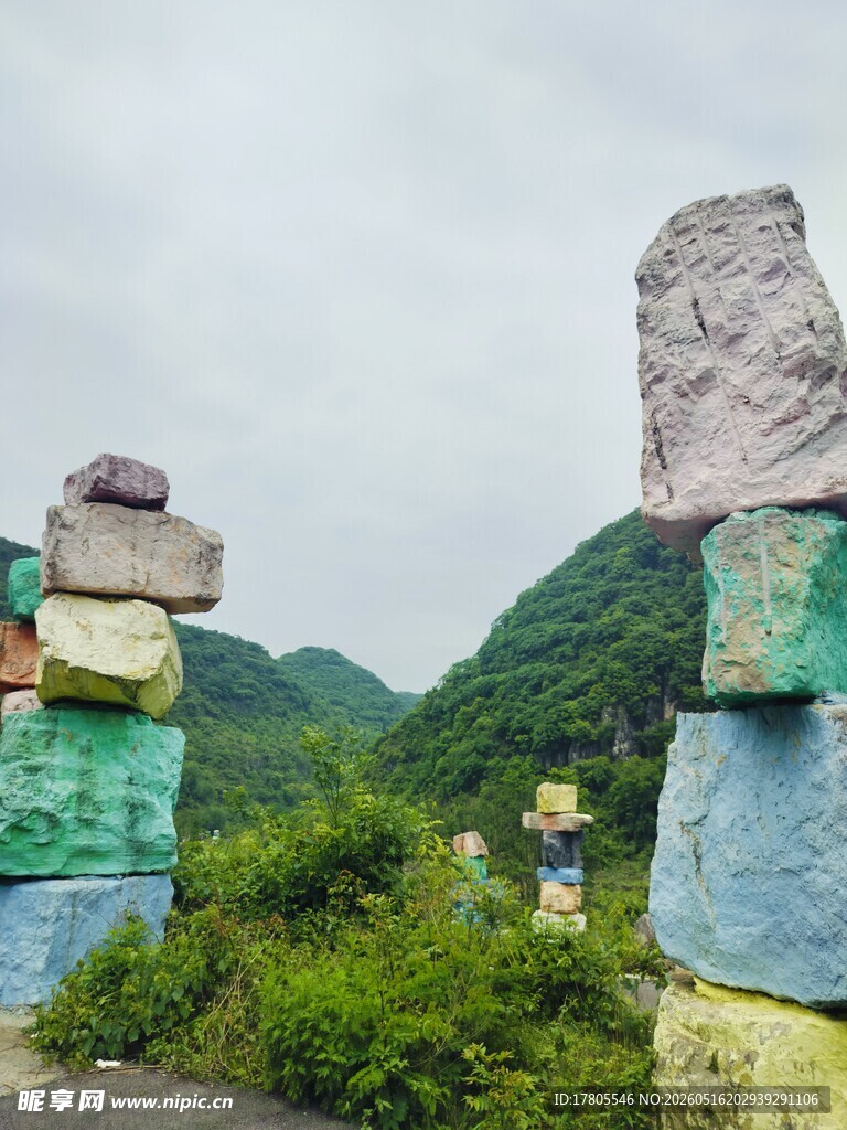 多彩石堆立于青山绿野间