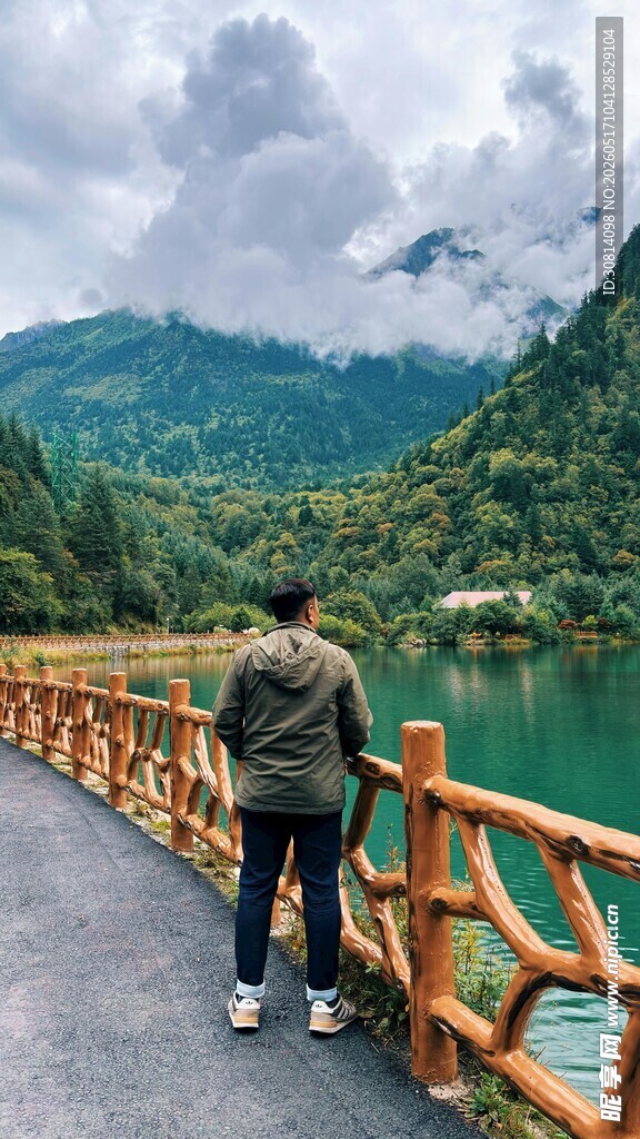 男子赏景于山水木桥间