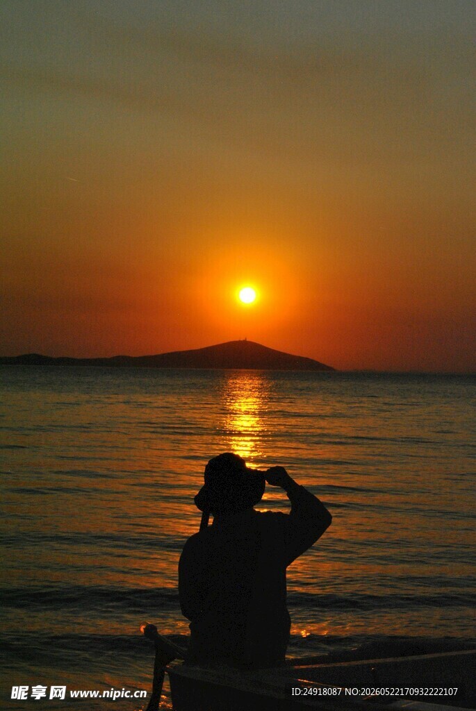 夕阳下的海边敬礼身影