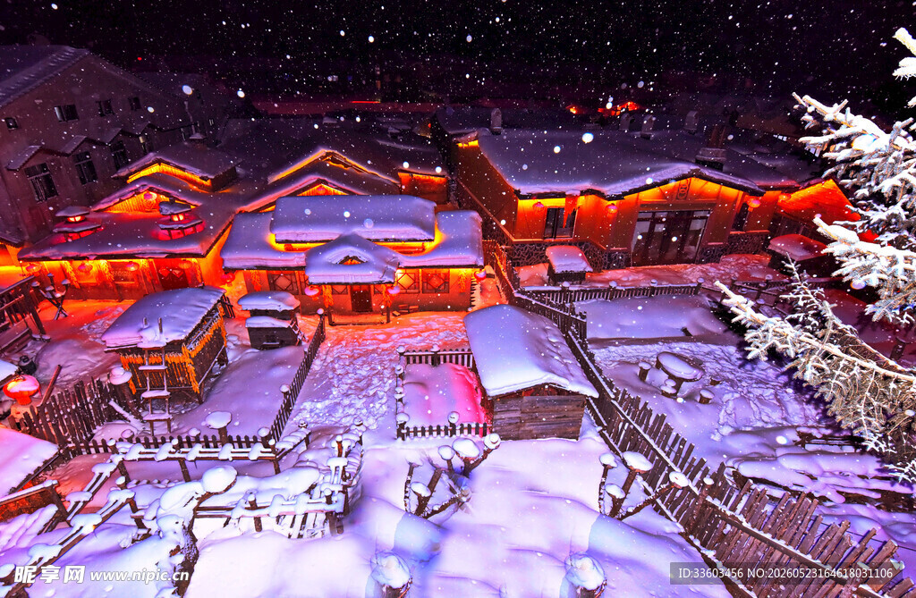 雪夜中的灯火通明小村庄