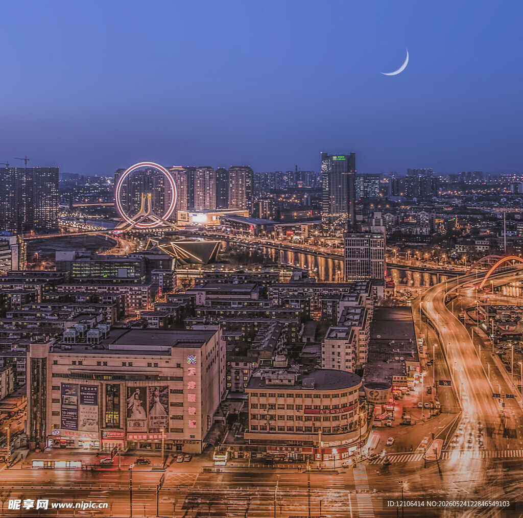 城市夜景中的摩天轮与新月
