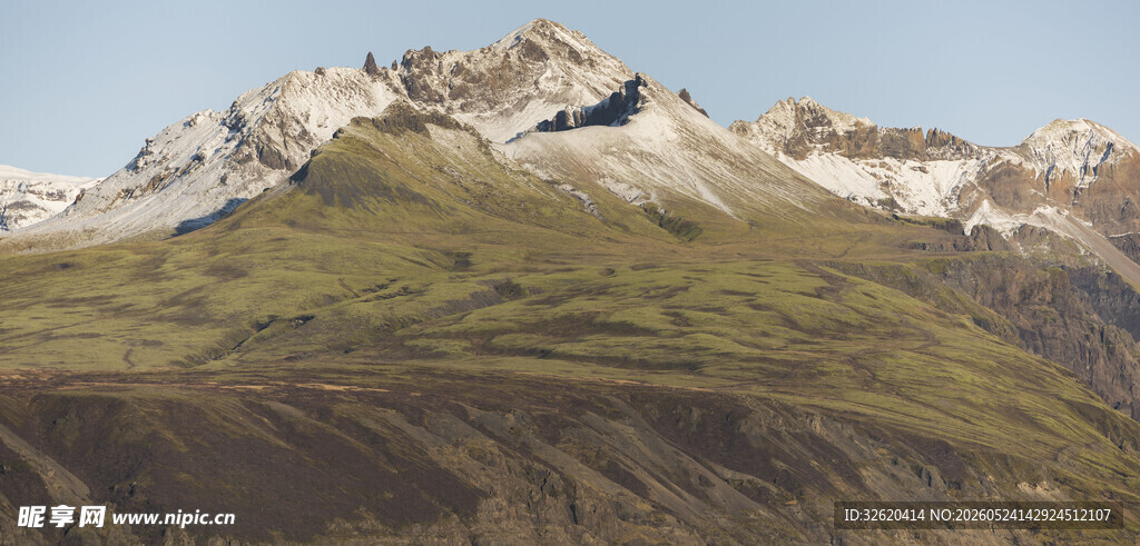 巍峨雪山下的翠绿山坡