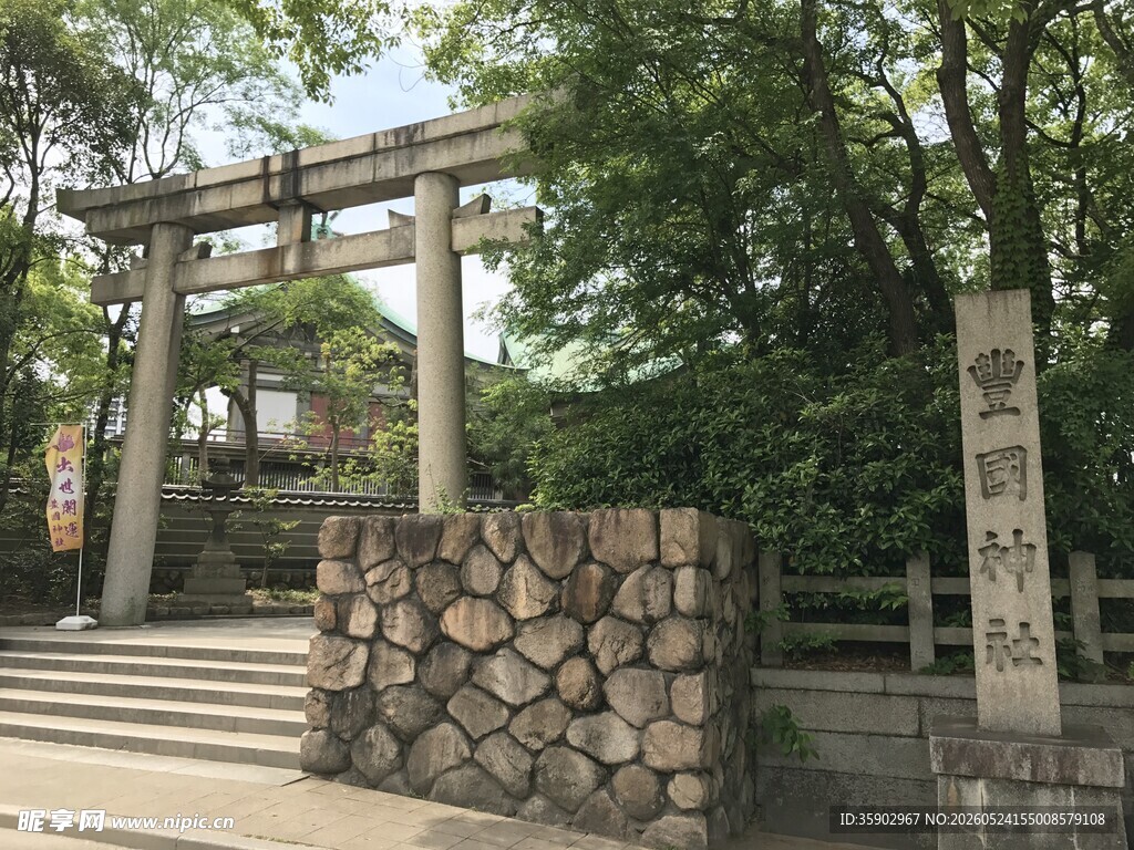 日式石制牌坊与绿树景观