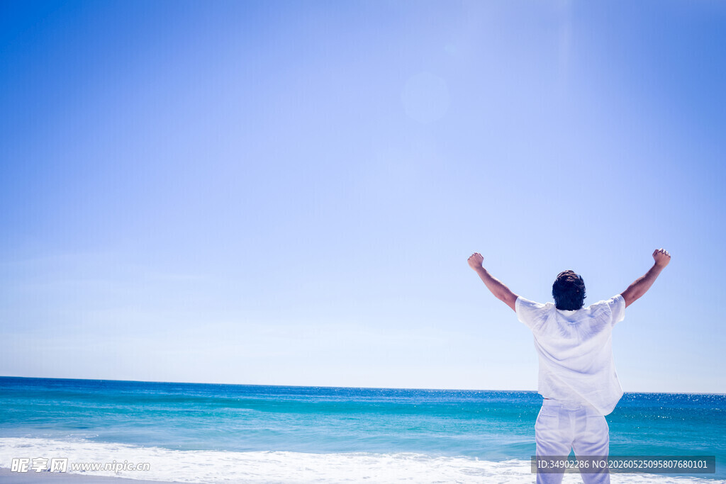 海边男子舒展双臂迎海风