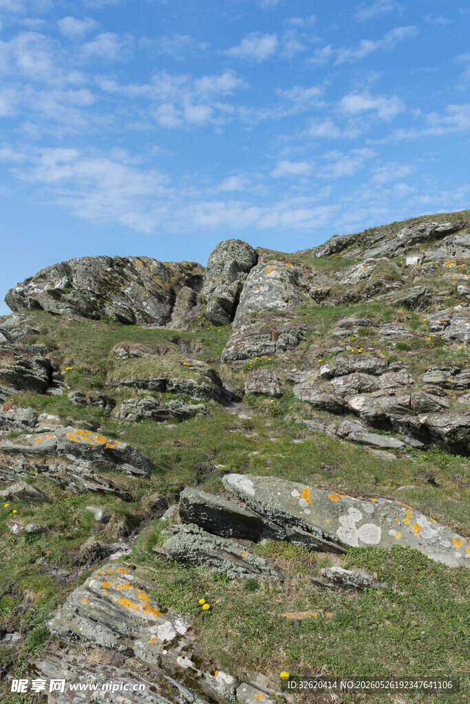 山间嶙峋岩石与蓝天绿草