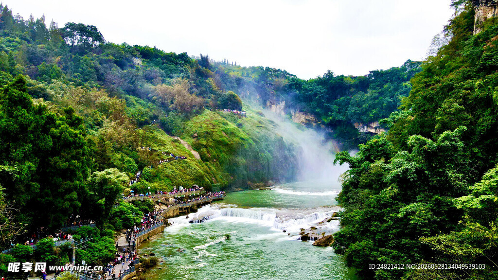 山间飞瀑下的翠绿河谷