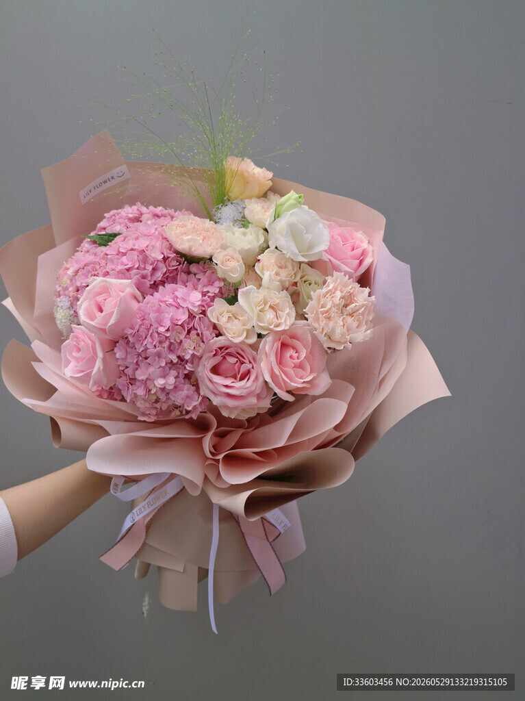 手捧粉色系鲜花花束