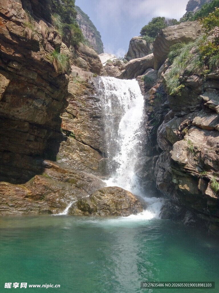山间飞瀑下的碧绿潭水