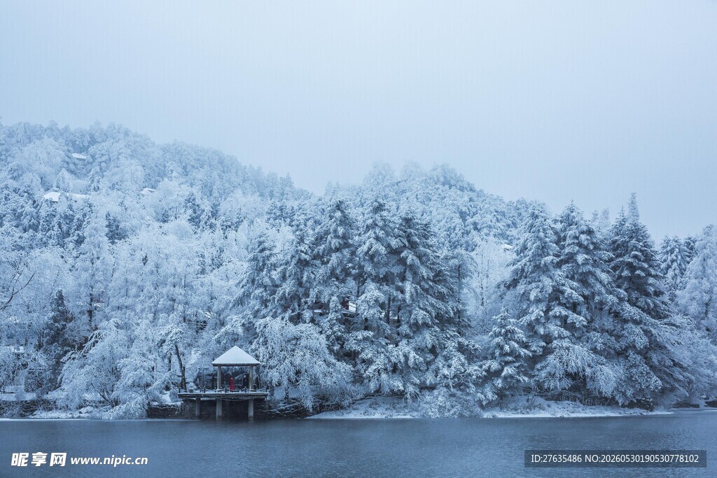 雪覆山林旁的静谧湖畔