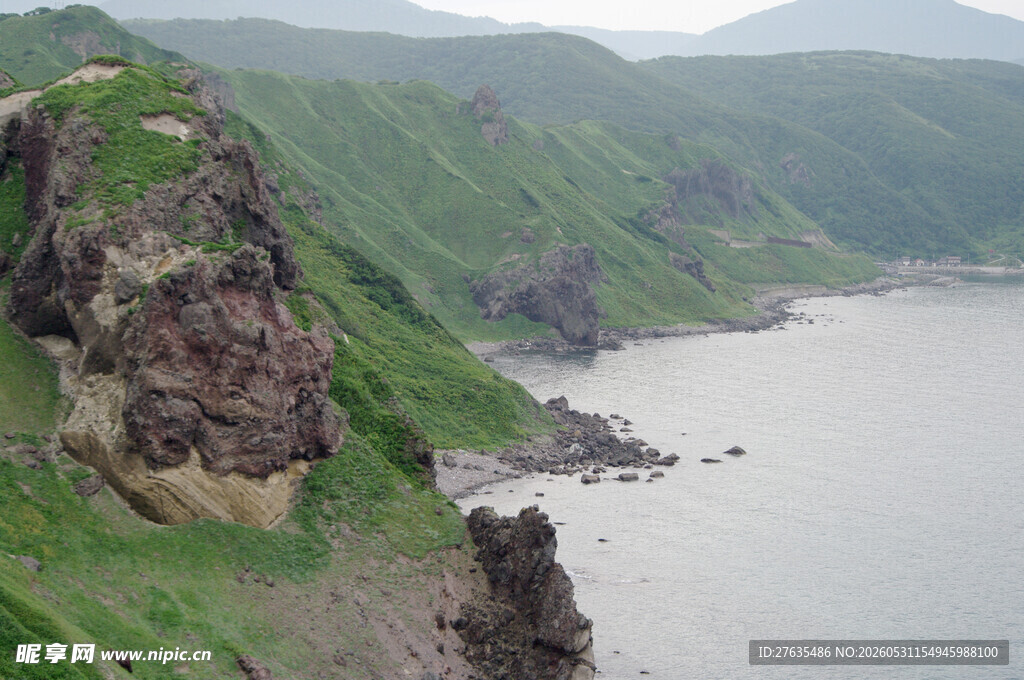 海岸边的陡峭岩石与青山