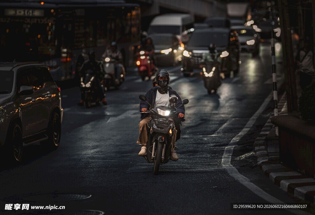 雨夜街头的摩托车骑行者