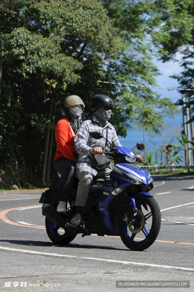 两人骑行于山林间公路