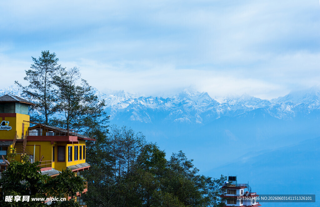 山间黄屋伴远处雪山美景