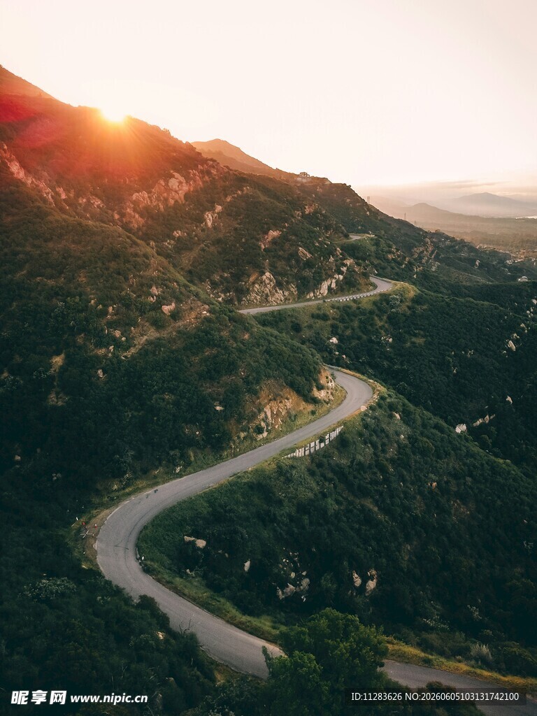 山间蜿蜒公路迎落日余晖