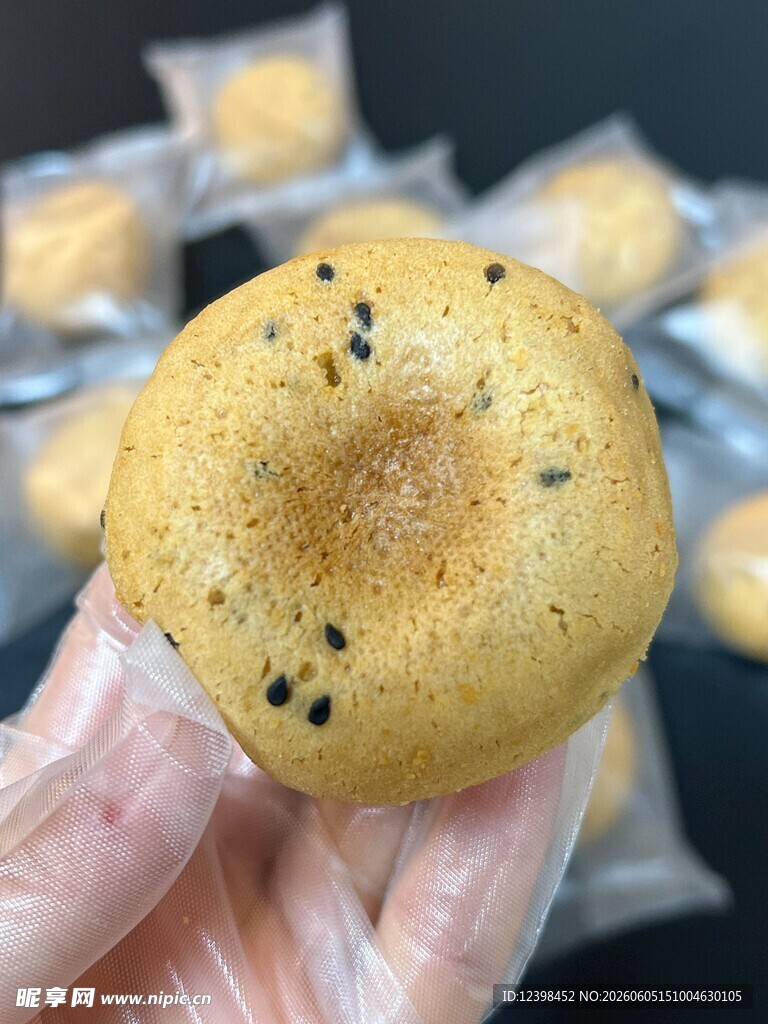 手拿芝麻点缀的美味糕点