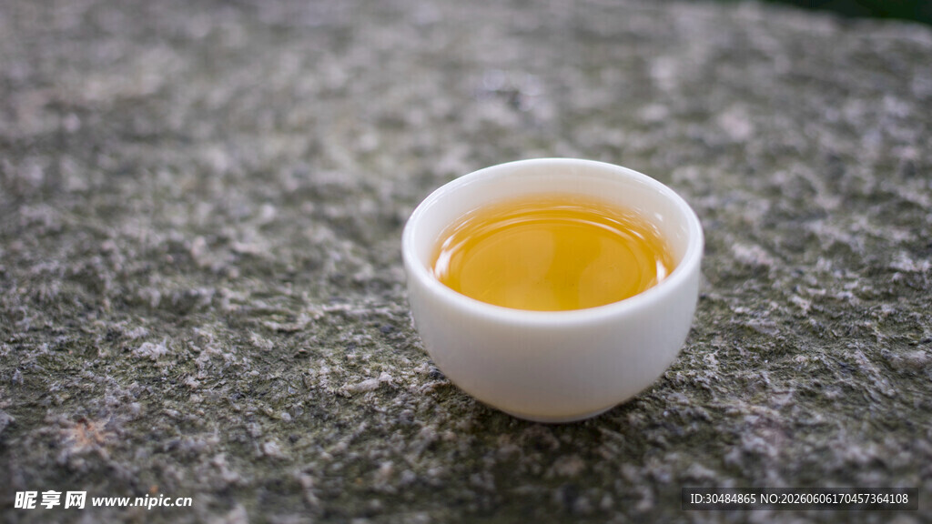 石上白杯盛金黄茶汤