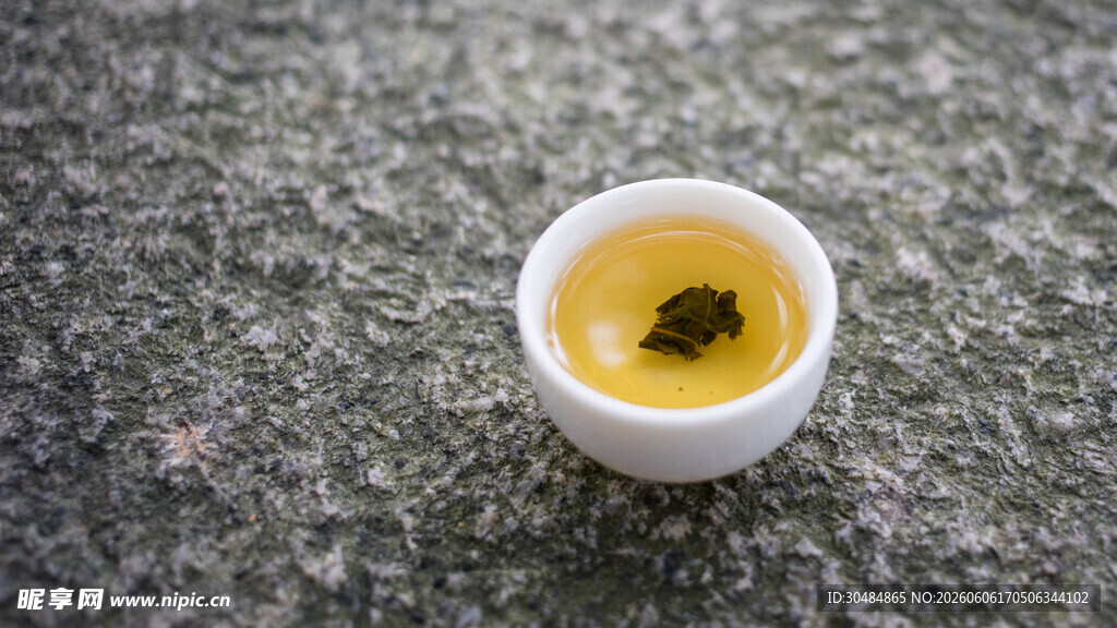 石上小杯装黄色茶饮