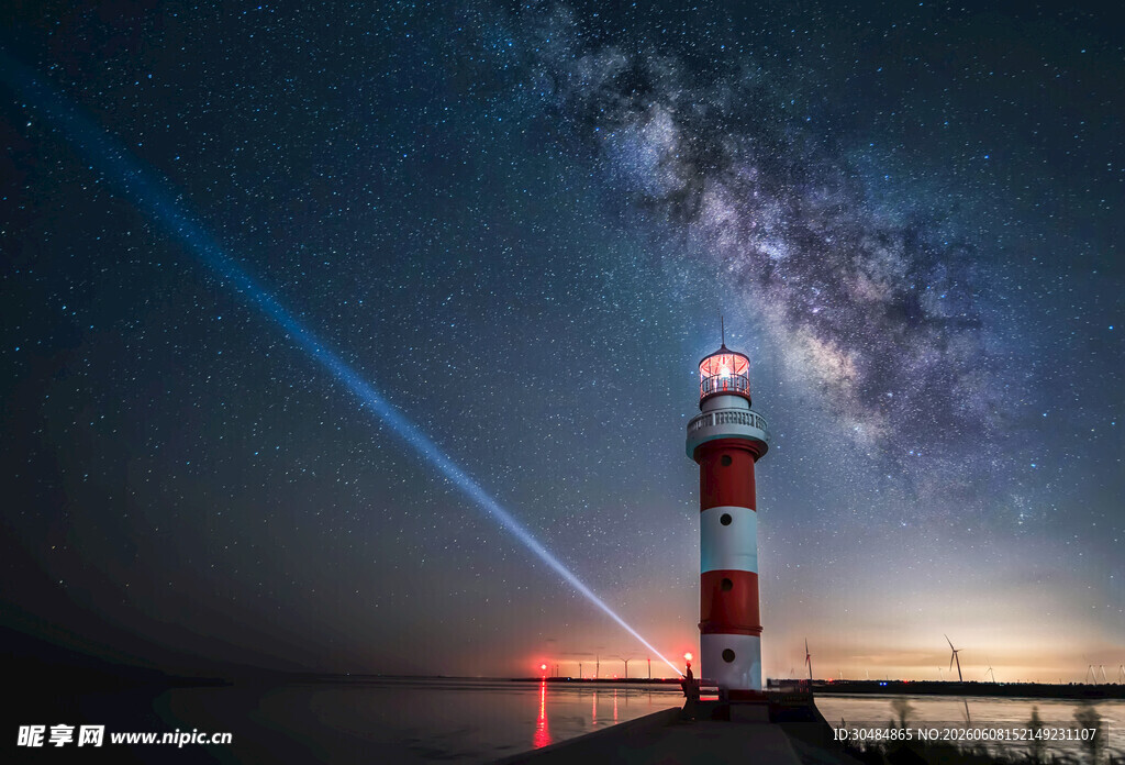 夜空下的灯塔与绚丽星芒