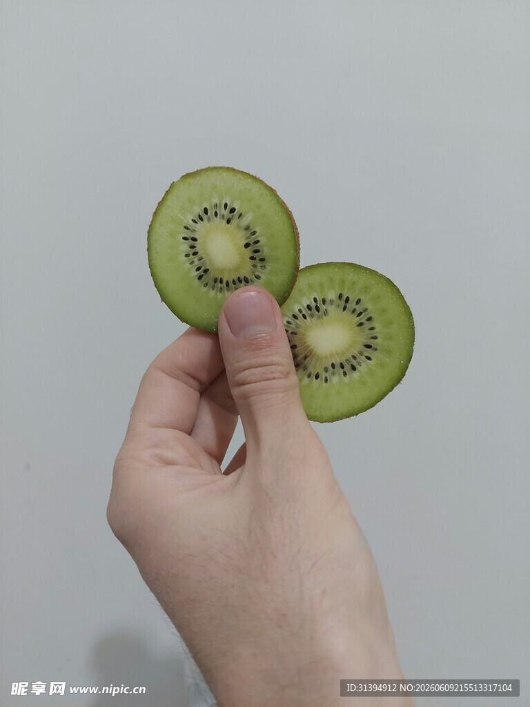 手托两片新鲜猕猴桃切片