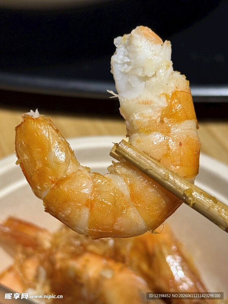 筷子夹起的诱人美味鲜虾