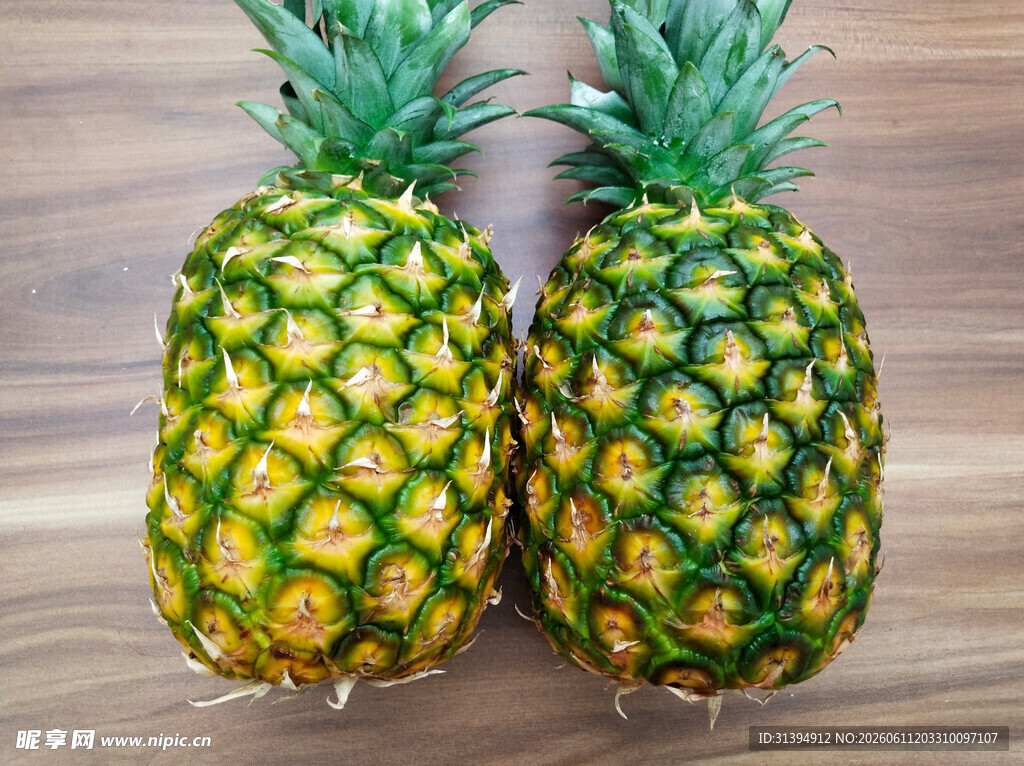 两个新鲜菠萝摆放在木面