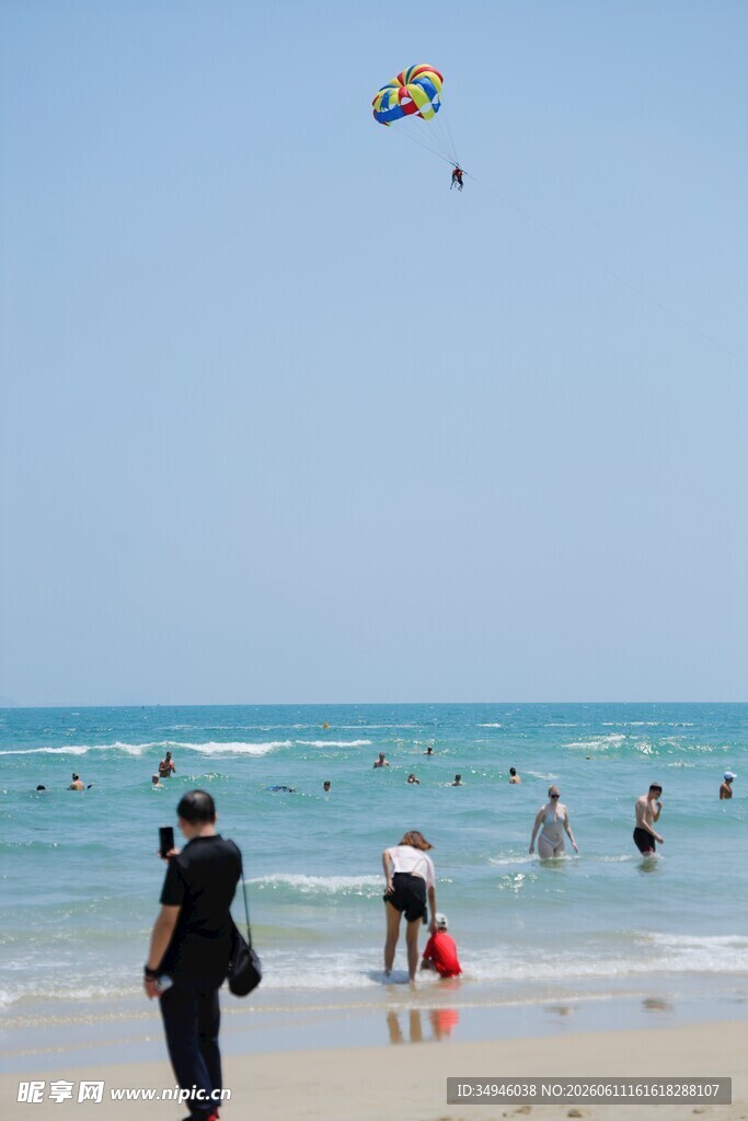 海边沙滩上的风筝与游人
