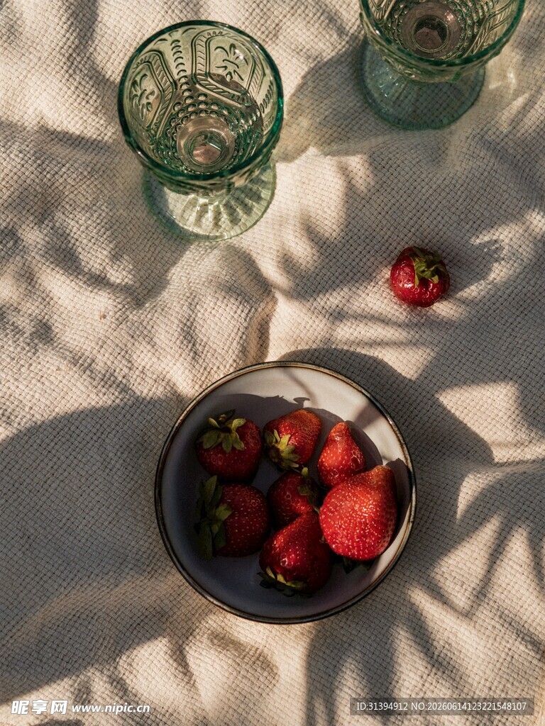 布上草莓与玻璃杯静物图