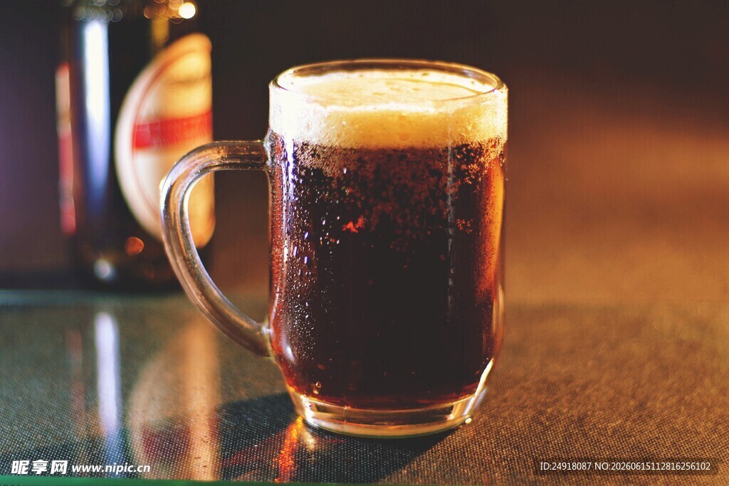 满溢泡沫的深色啤酒杯