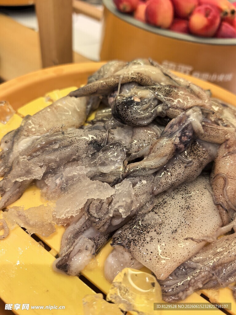 新鲜墨鱼摆放在木盘上