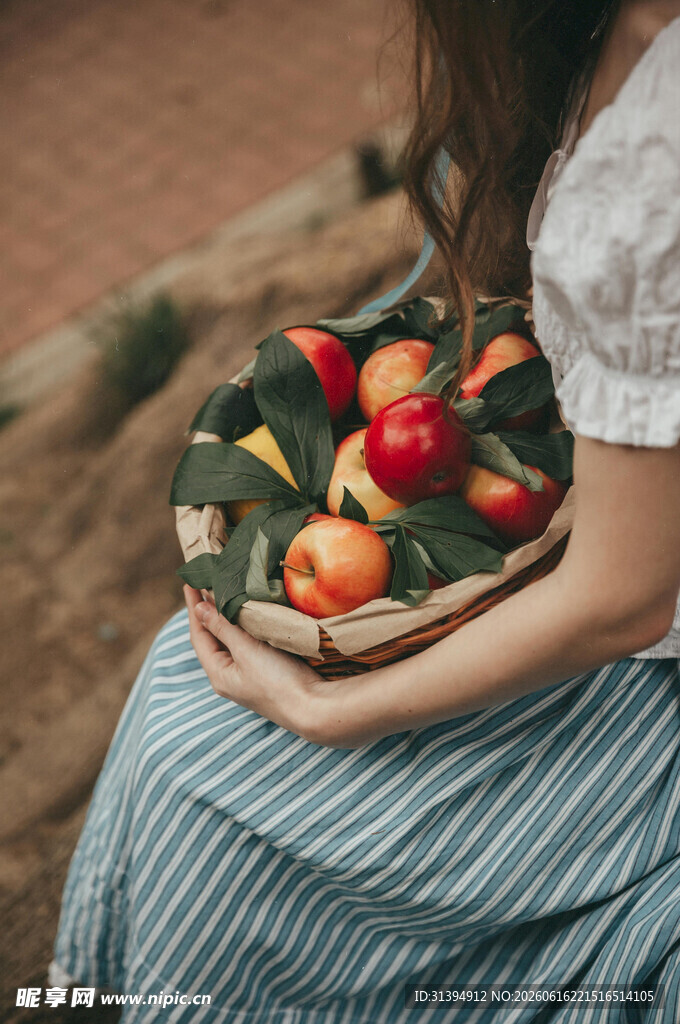 女子手持装满蔬果的篮子