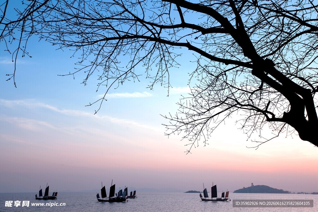 湖畔枯树映夕阳下扁舟
