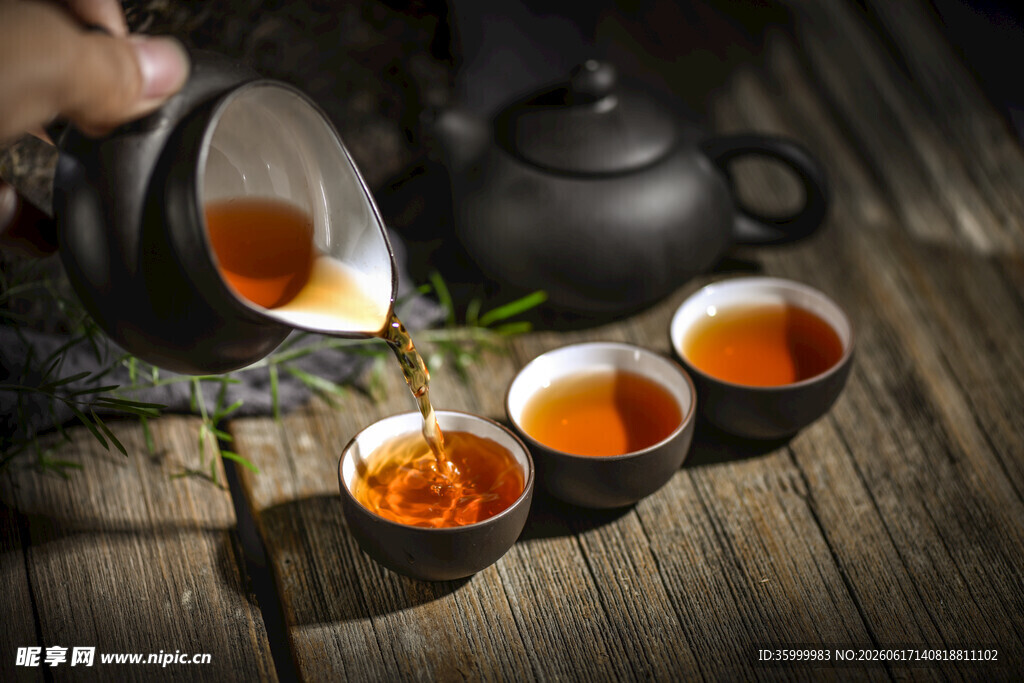 茶壶倒茶至古朴茶杯中