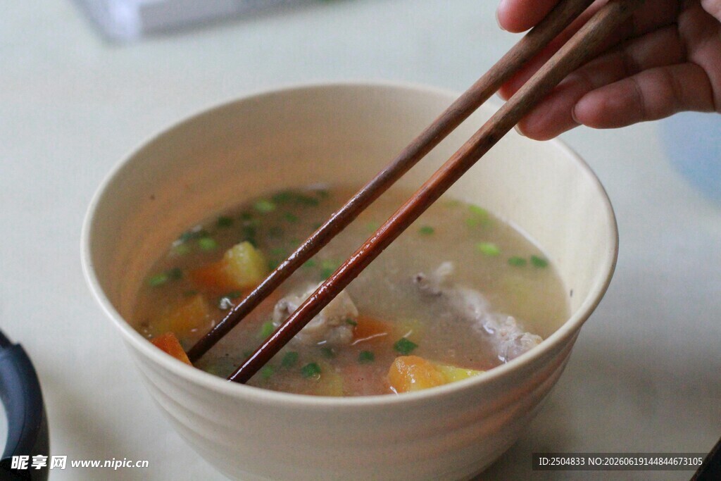 手持筷子夹取碗中食物