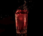 红色液体倾入高脚玻璃杯