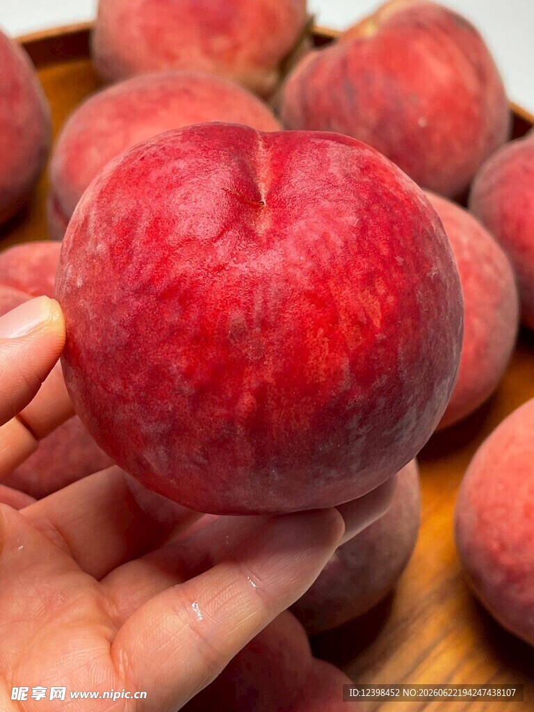 手捧鲜红多汁大桃子