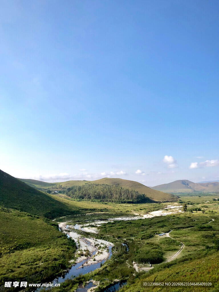 山间溪流蜿蜒于翠绿山谷