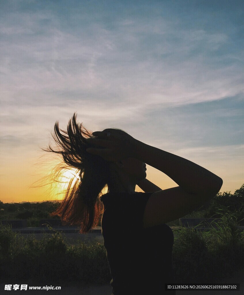 夕阳下舞动发丝的女子