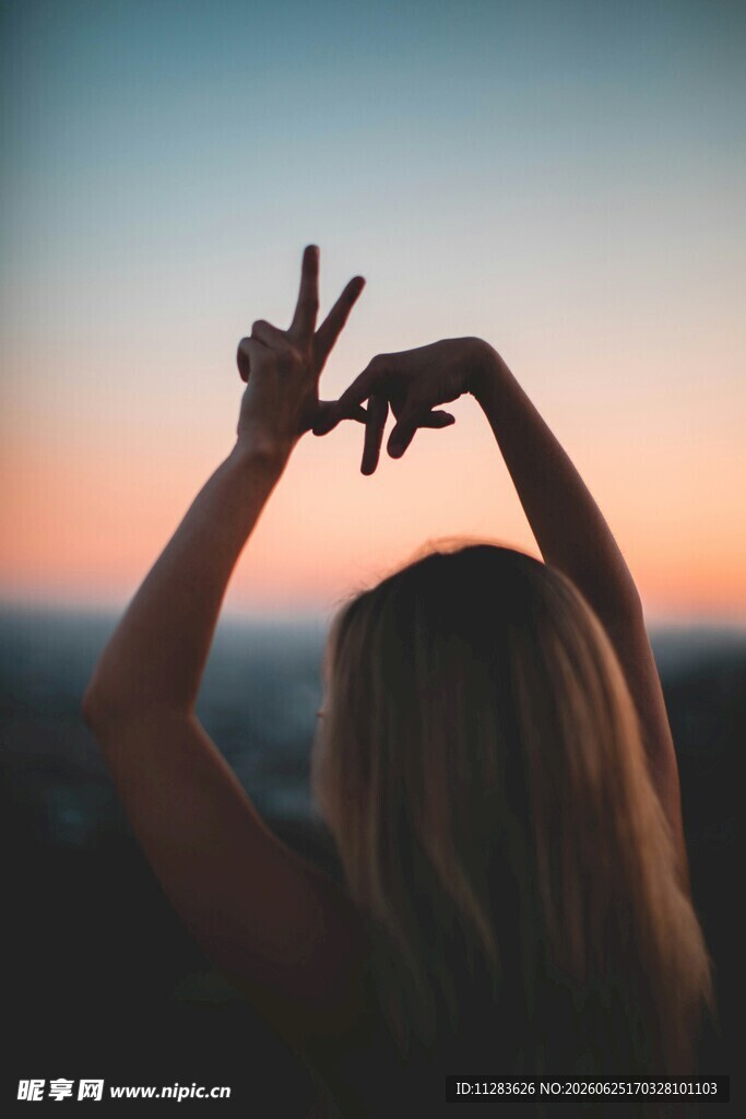 夕阳下女子比手势剪影